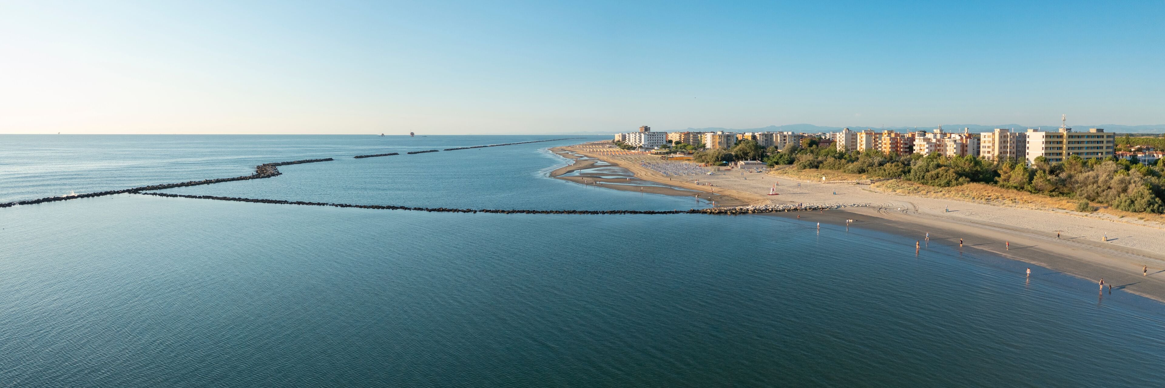 Aerial shot of sandy beach with umbrellas, typical adriatic shore.Summer vacation concept.Lido Adriano town,Adriatic coast, Emilia Romagna,Italy.