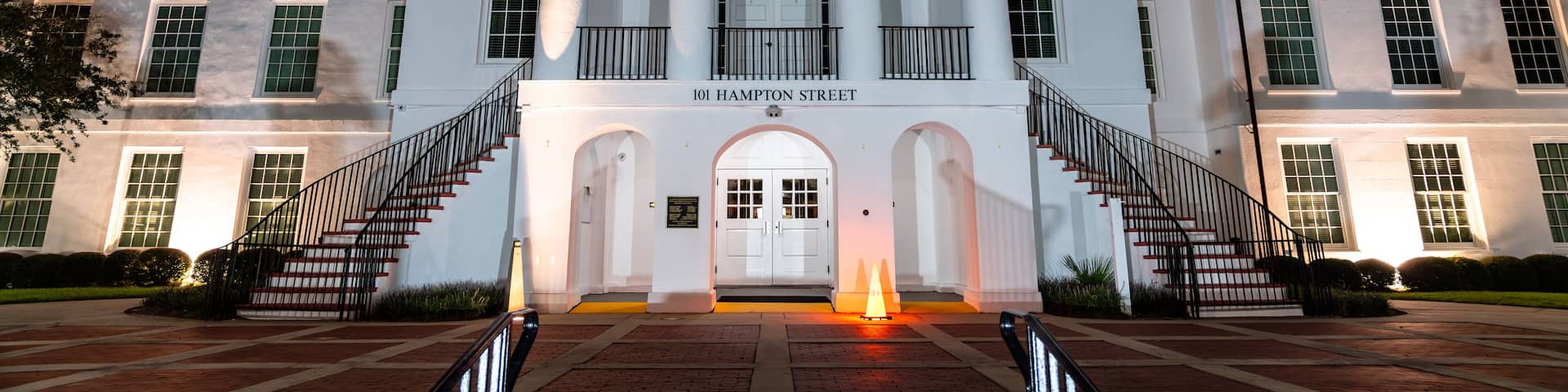 Colleton County Courthouse in Walterboro, South Carolina. Historic white building features columns and stairs at 101 Hampton Street at night