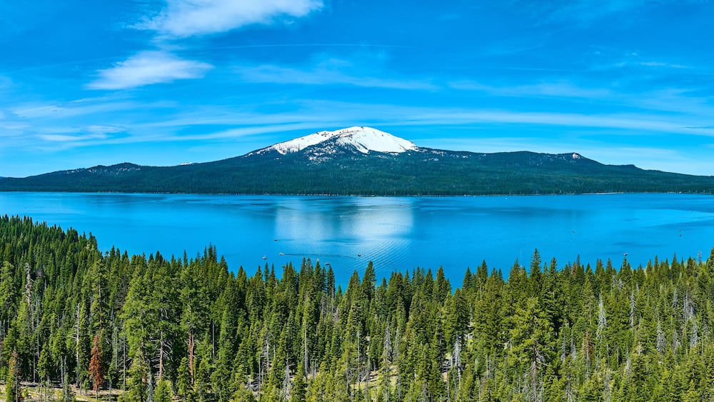 A snow-capped mountain, a large lake, and a dense forest.