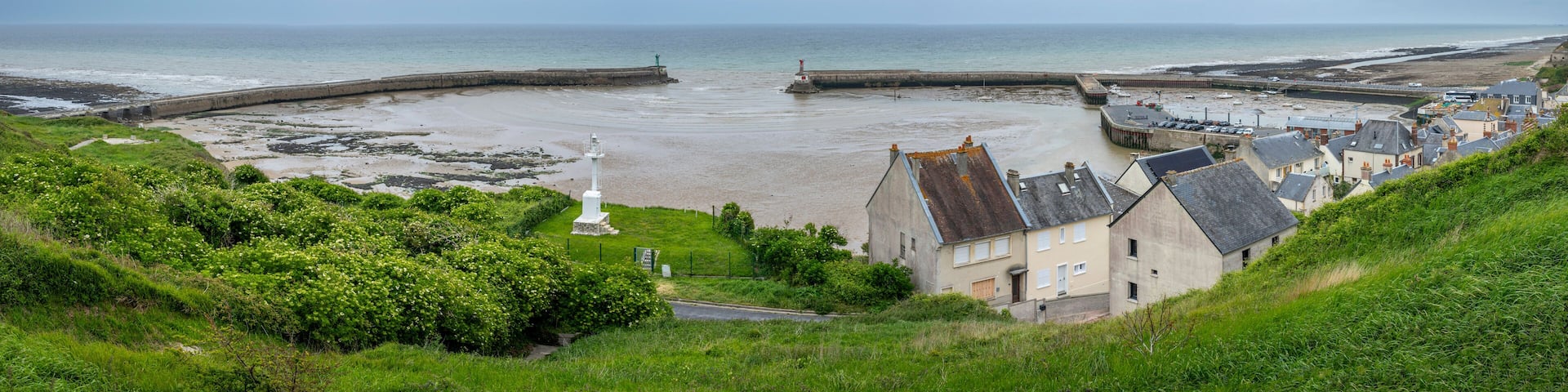 Port-en-Bessin-Huppain, France - 05 15 2025: Panoramic view of the harbor, houses and the sea from the top of the cliffs.