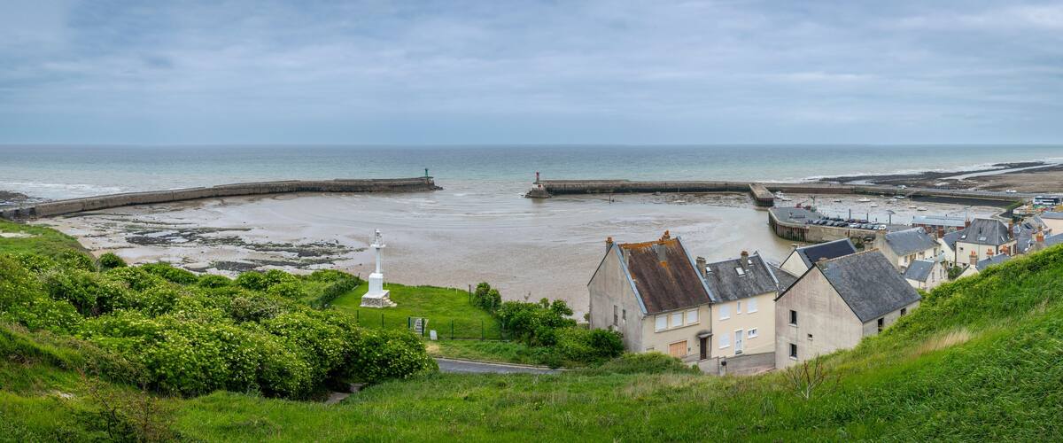 Port-en-Bessin-Huppain, France - 05 15 2025: Panoramic view of the harbor, houses and the sea from the top of the cliffs.