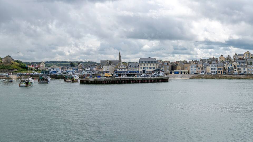 A coastal town with a harbor, boats, and historic buildings.