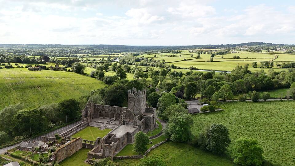 A historic castle surrounded by lush green fields and rolling hills.