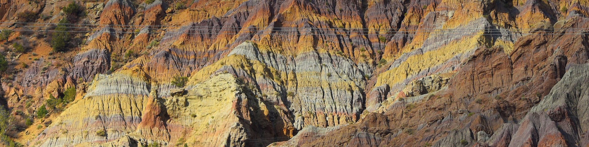 While driving in the early morning from Riffle to Meeker, this mix of old wearing mountains and modern power-lines just struck me.
The sun just lit the face with the raged edges right, and the power-lines just in front is a remainder that it is the new power.
I think it is #Golden with al the vibrant yellow of the rock layers.