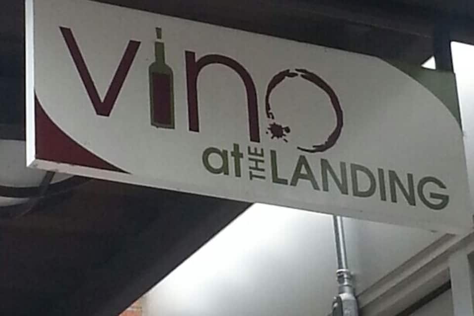 A sign with the text 'vino at the landing'.