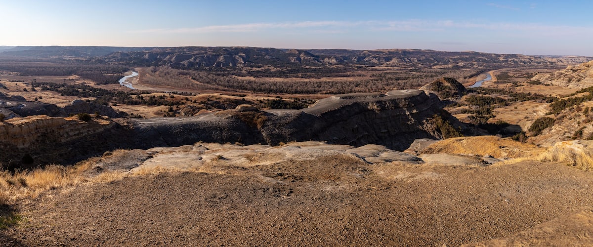 A rugged landscape with a winding river, rocky terrain, and sparse vegetation.