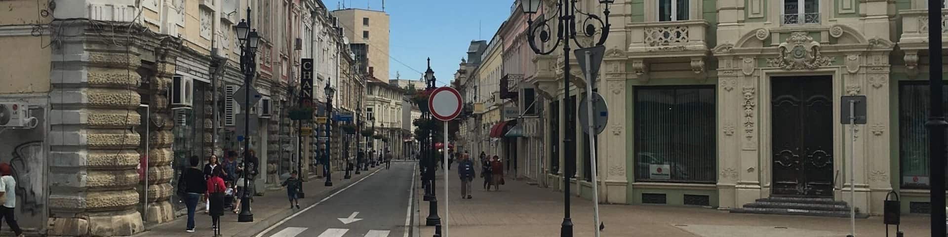 A street with historic buildings, a clear sky, and a no-entry sign.