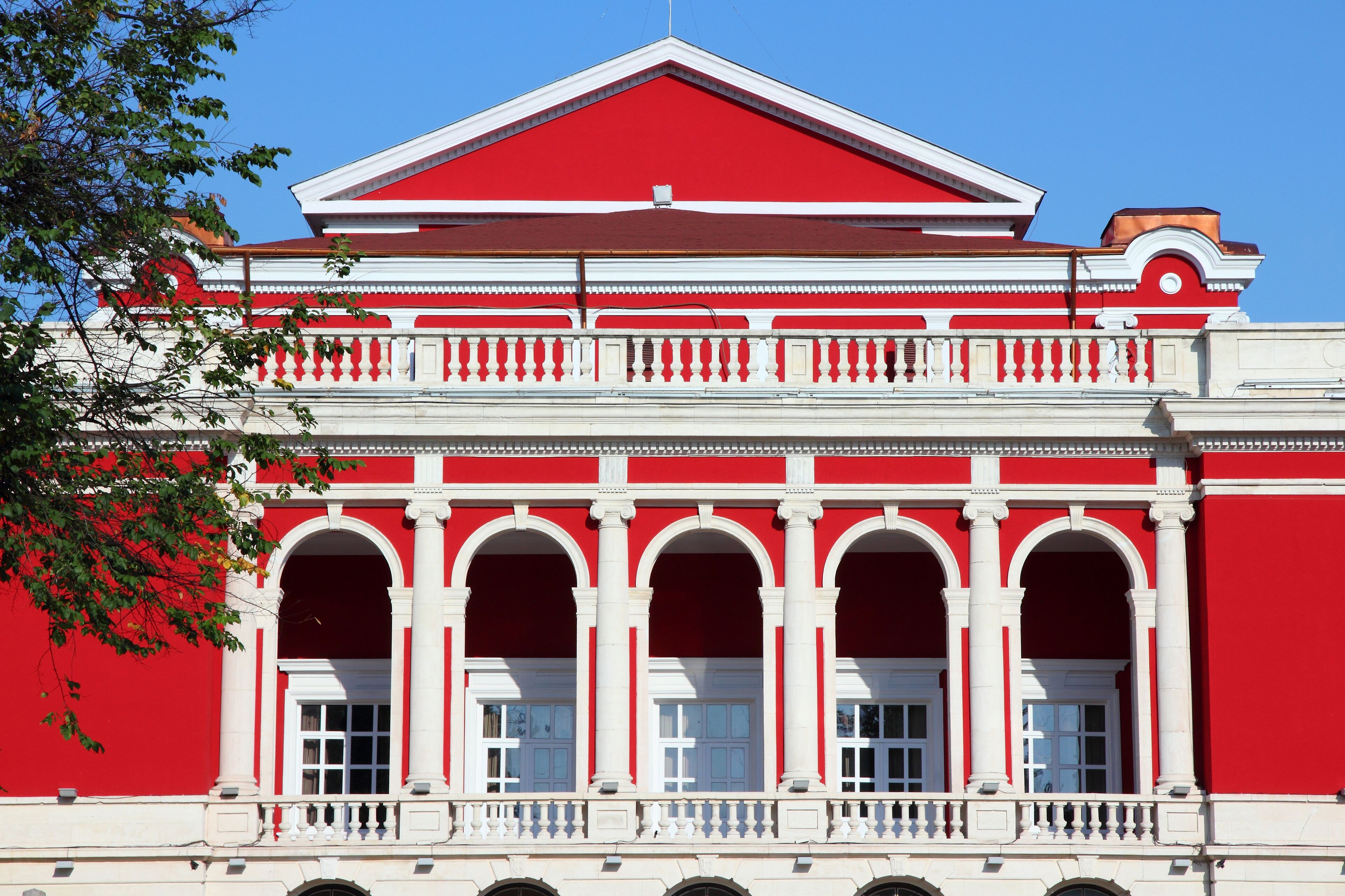 A red and white building with arched windows and columns.