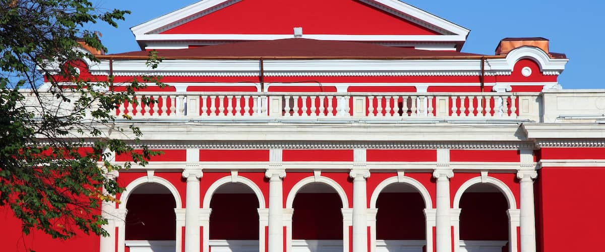 A red and white building with arched windows and columns.