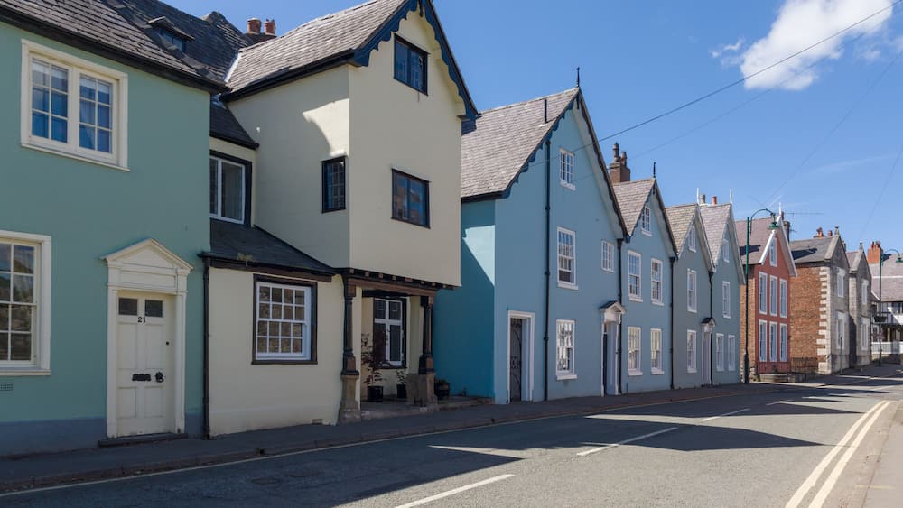 A street lined with colorful houses, a clear blue sky, and a calm road.