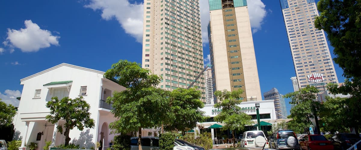 A cityscape with tall buildings, a Starbucks Coffee, and parked cars.
