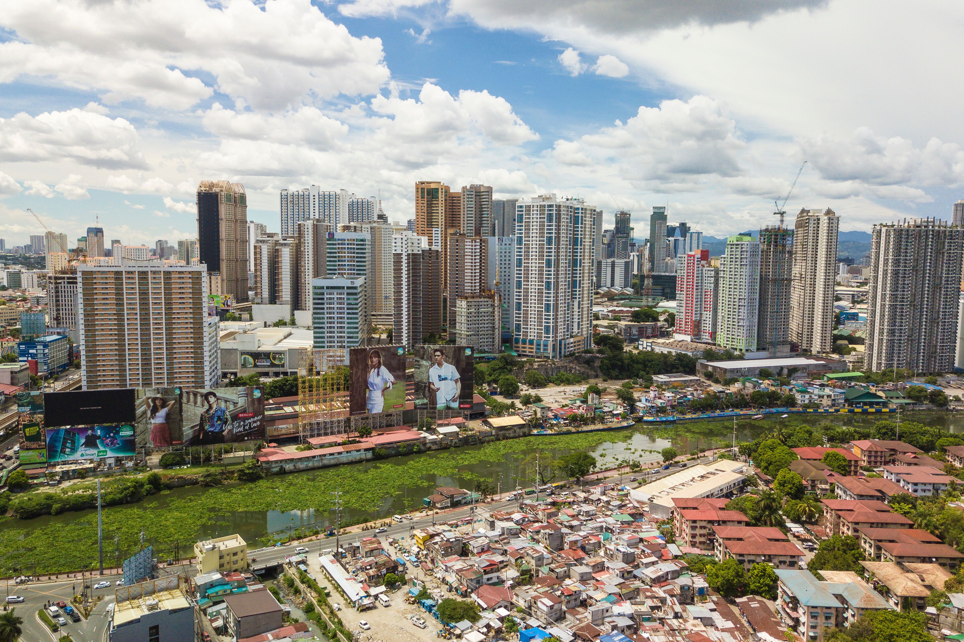 Metro Manila, Philippines - Condominiums and large billboards in Mandaluyong City loom over the Pasig River and slum areas in Makati.