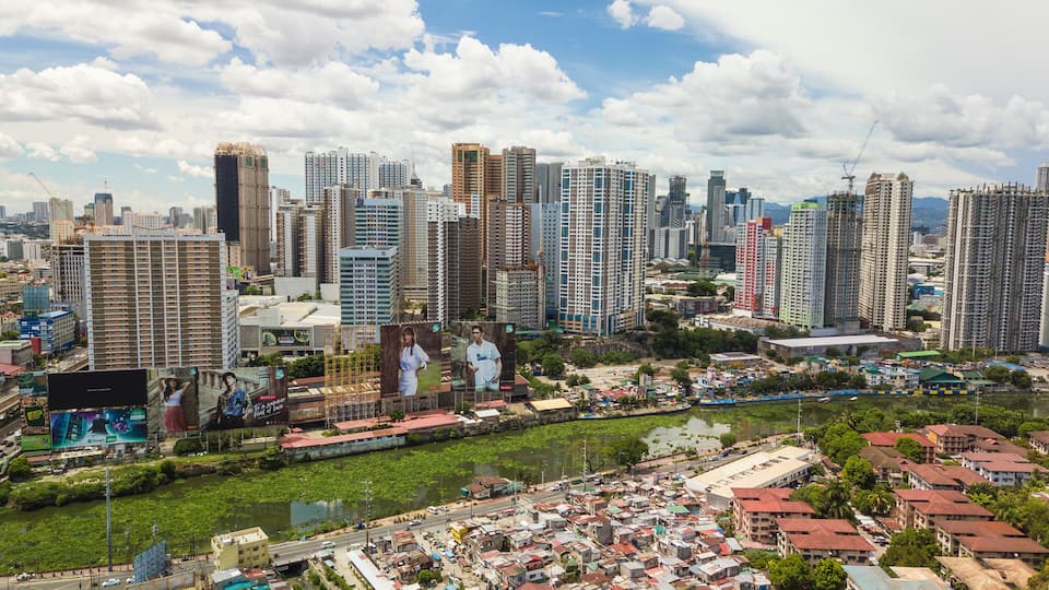 A cityscape with high-rise buildings, a river, and a densely populated area with smaller houses.