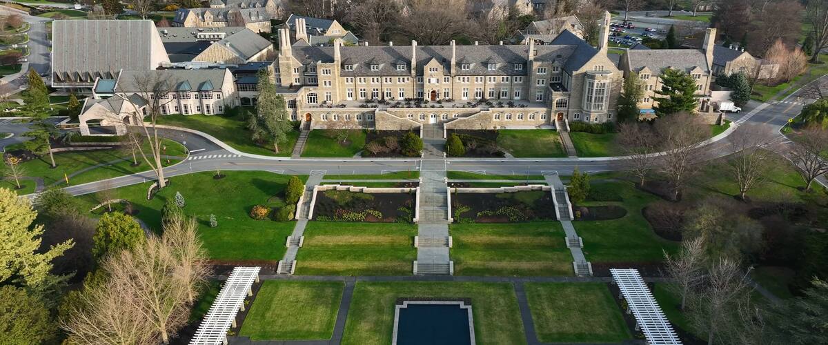 Aerial view of the historic Masonic Village featuring stone architecture, lawns, gardens, and a reflecting pool in West Donegal Township, Pennsylvania, United States.