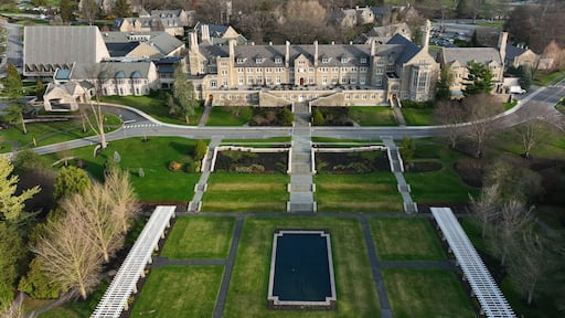 Aerial view of the historic Masonic Village featuring stone architecture, lawns, gardens, and a reflecting pool in West Donegal Township, Pennsylvania, United States.