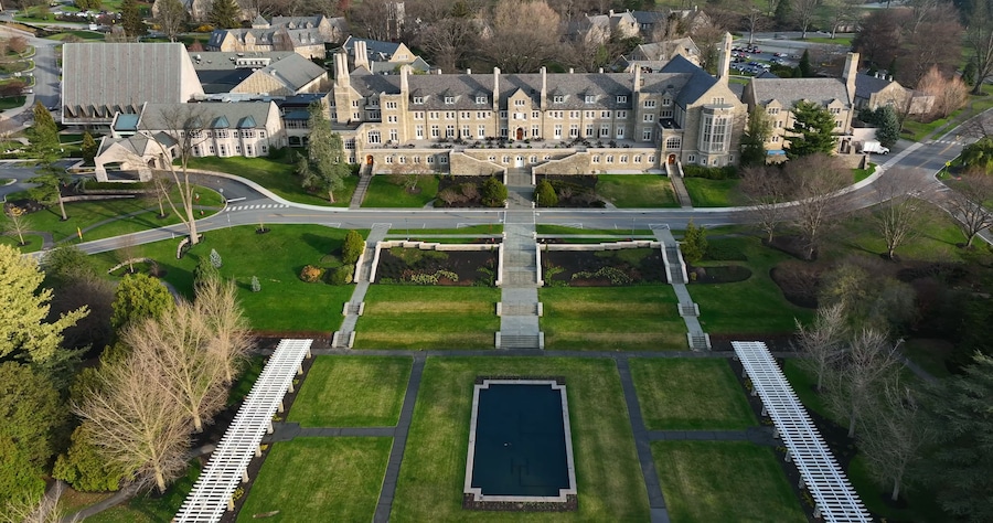 Aerial view of the historic Masonic Village featuring stone architecture, lawns, gardens, and a reflecting pool in West Donegal Township, Pennsylvania, United States.