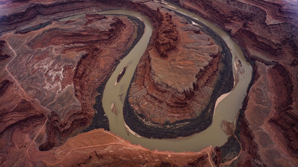 A river winding through a canyon with layered rock formations.