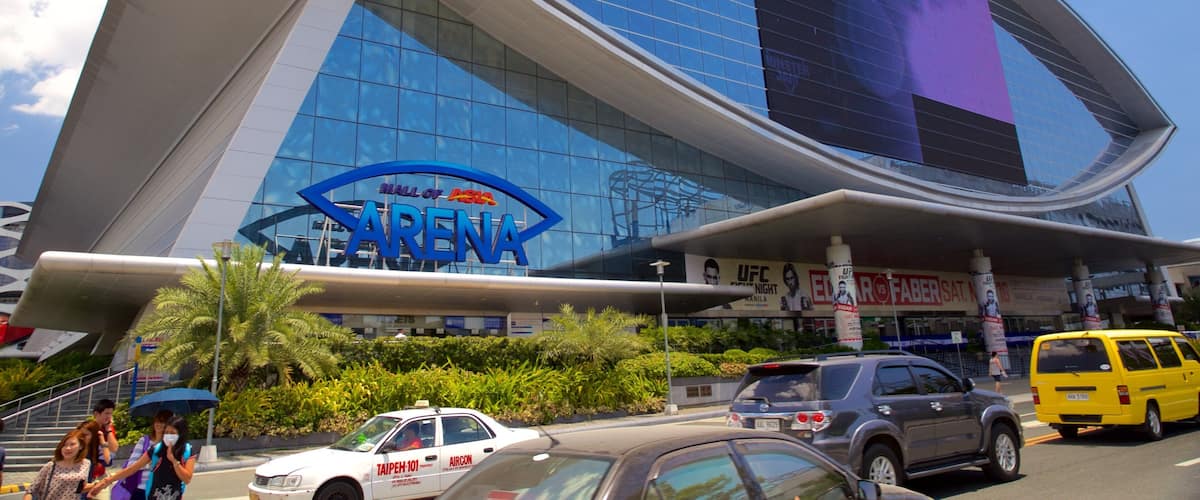A modern building with a 'Hall of Fame' sign, surrounded by palm trees and busy traffic.