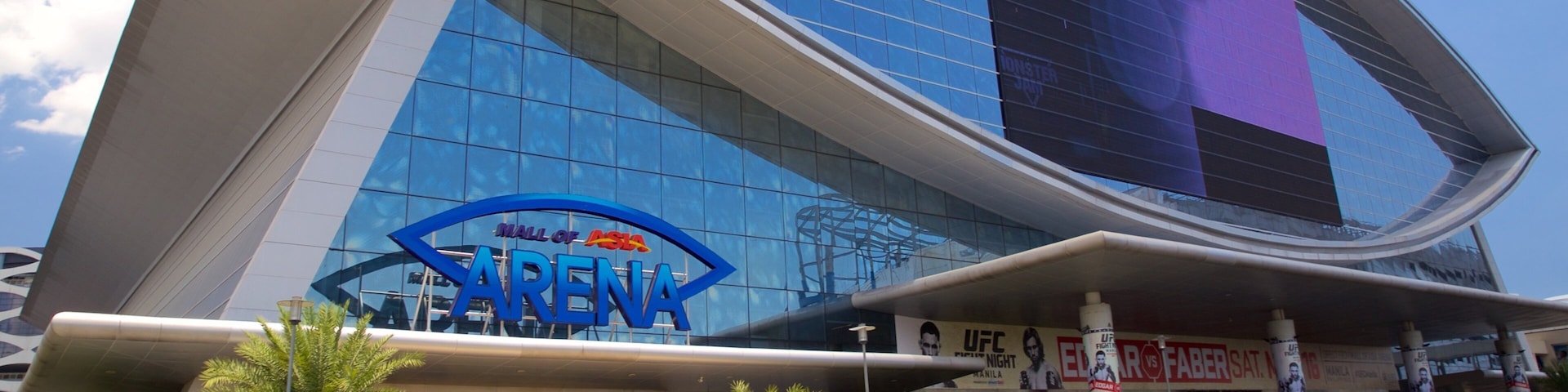 A modern building with a 'Hall of Fame' sign, surrounded by palm trees and busy traffic.
