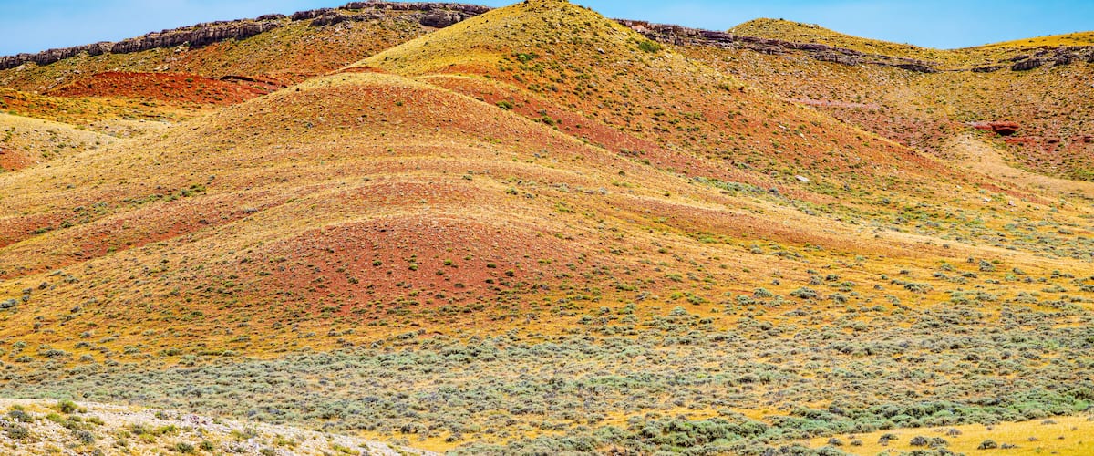 A desert landscape with rolling hills and sparse vegetation.