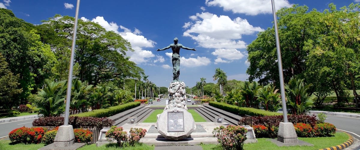 Quezón City que incluye una estatua o escultura y un jardín