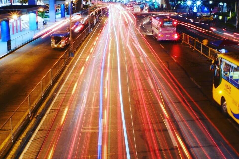 A busy urban intersection with multiple lanes of traffic and a bus.