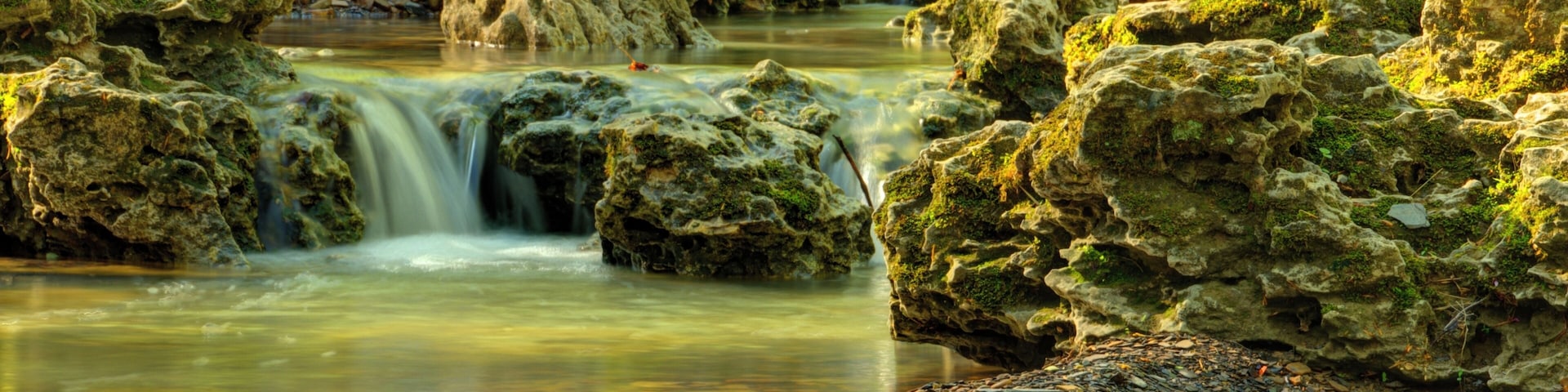 A beautiful stream runs along a scenic drive that leads to the Canopy Tree Walk, an bridge.