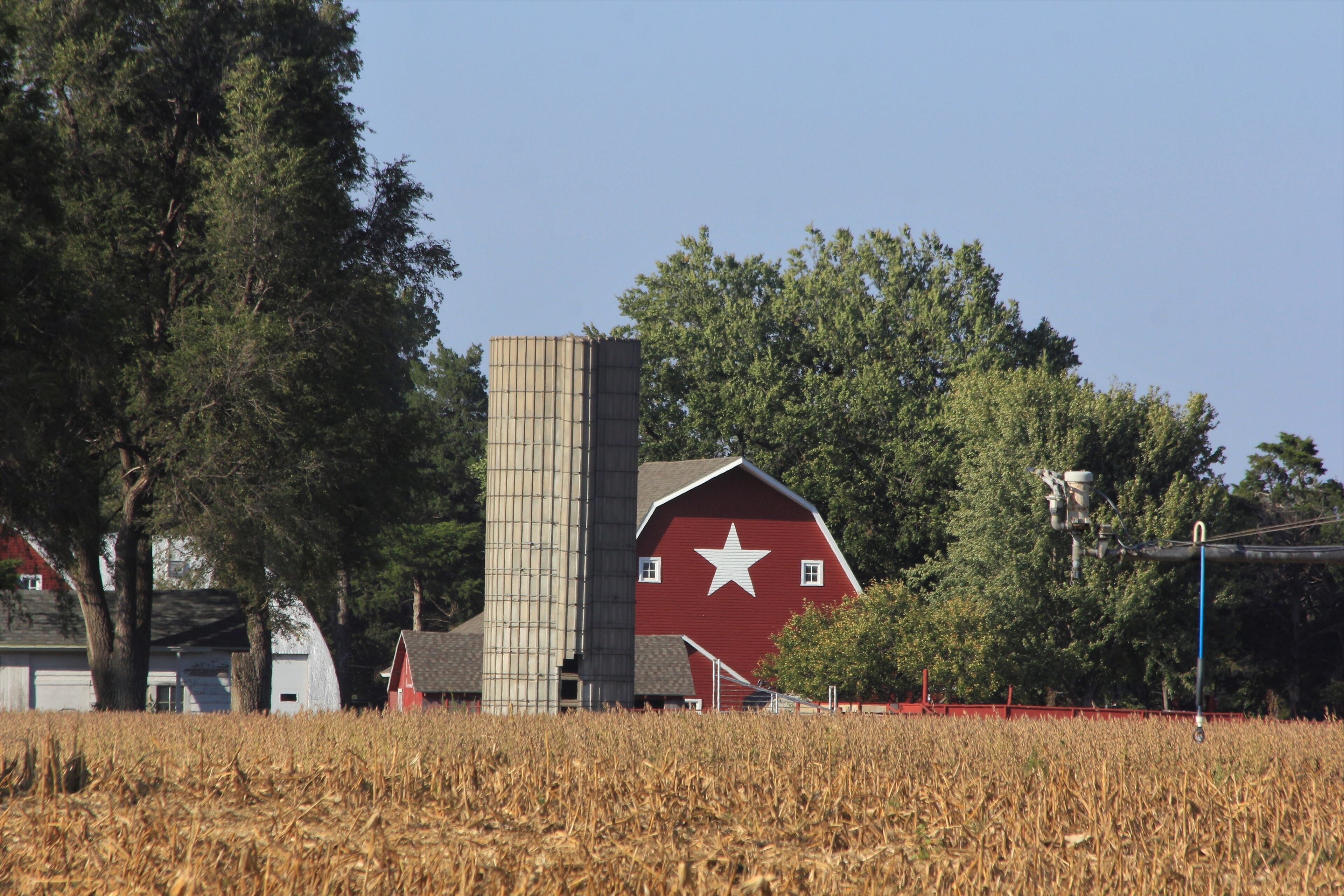 red barn in the countryside with blue sky and a white star on the barn. South of Sterling Kansas USA out in the country.