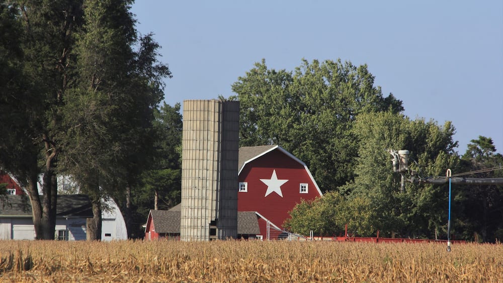 red barn in the countryside with blue sky and a white star on the barn. South of Sterling Kansas USA out in the country.