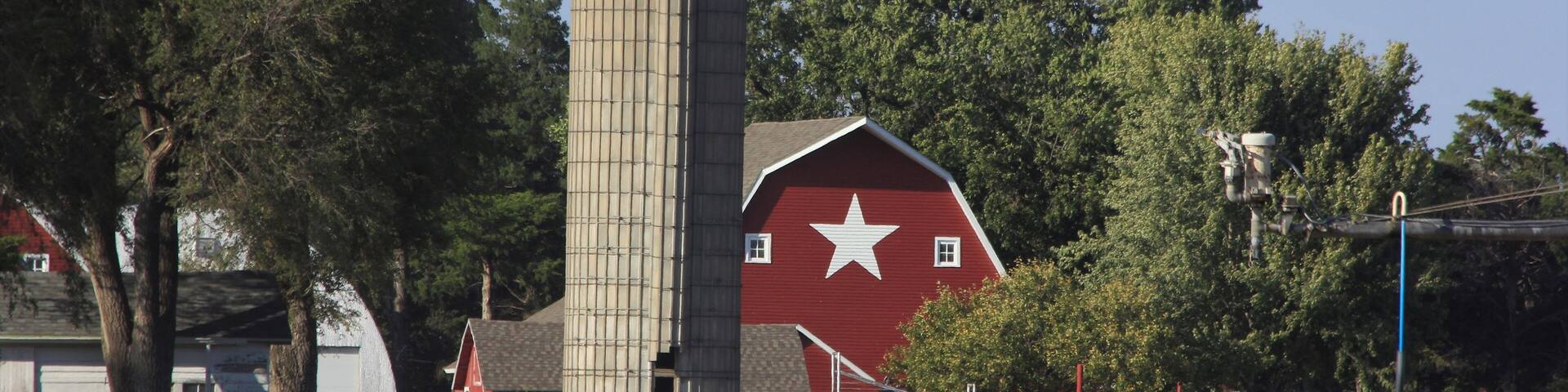 red barn in the countryside with blue sky and a white star on the barn. South of Sterling Kansas USA out in the country.