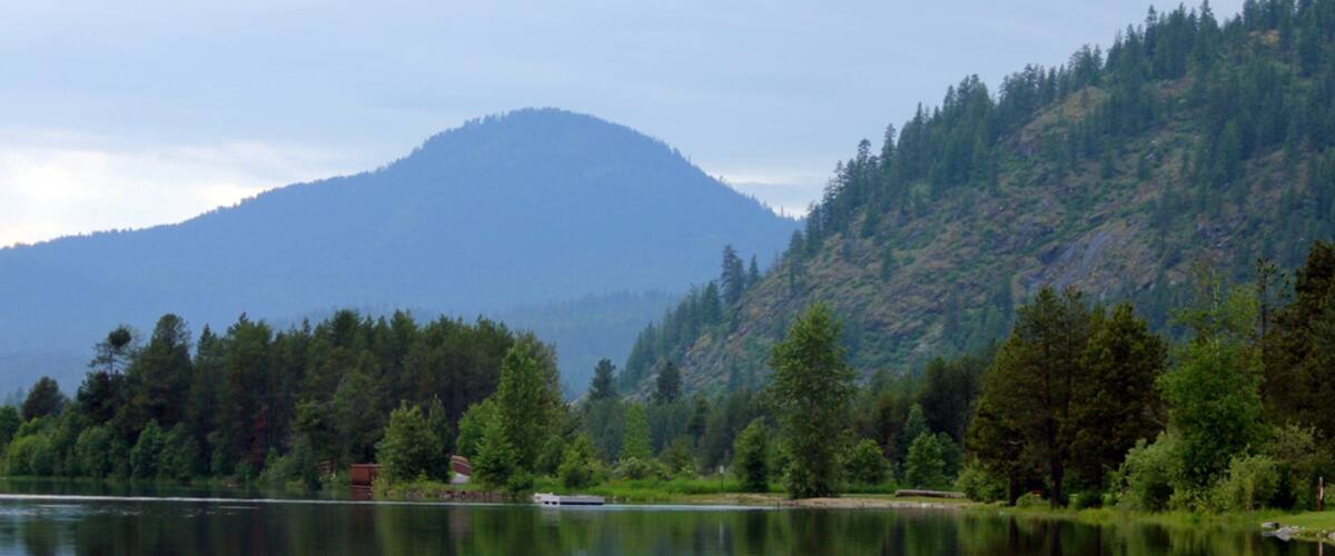 Sandpoint welches beinhaltet Waldmotive, See oder Wasserstelle und Berge