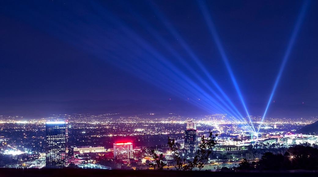 Huge spotlight rays over the night panorama of Los Angeles city