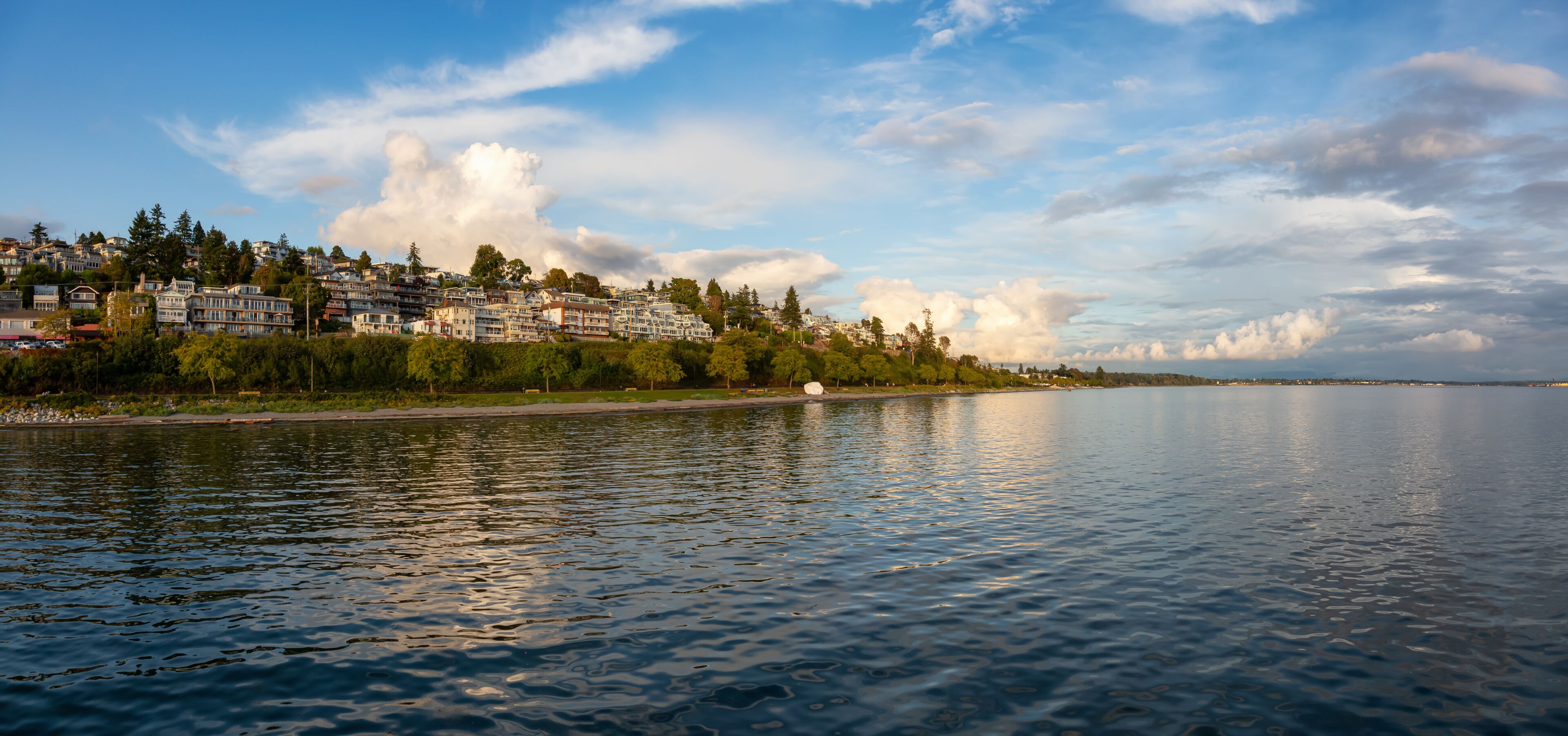 White Rock, British Columbia, Canada. Beautiful Panoramic View of Residential Homes on the Ocean Shore during a sunny and cloudy summer sunset.