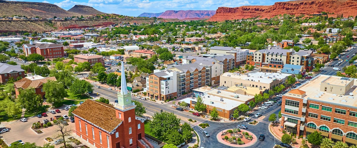 Aerial Historic Red Brick Church Downtown St George Utah with Red Rock Mesas