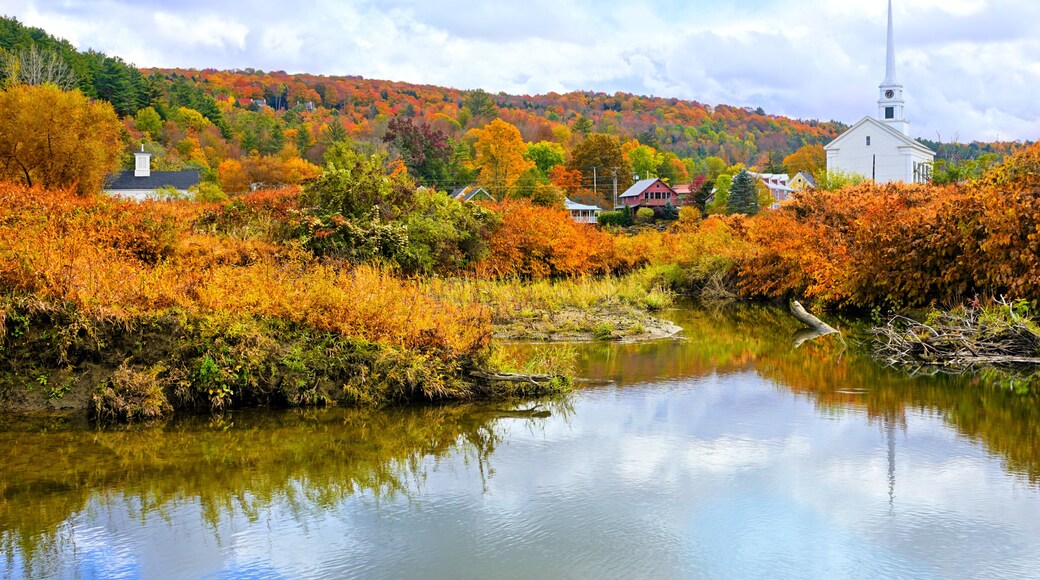 Autumn view of the town of Stowe with white church and fall colors along the Little River, Vermont, USA