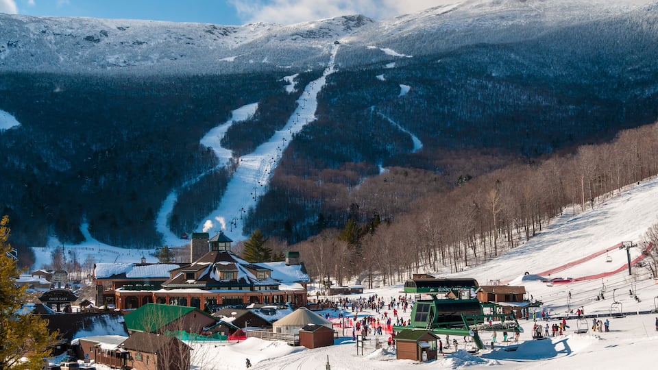 Spruce Peak Lodge in the winter with Mt. Mansfield in the background, Stowe, Vermont, USA
