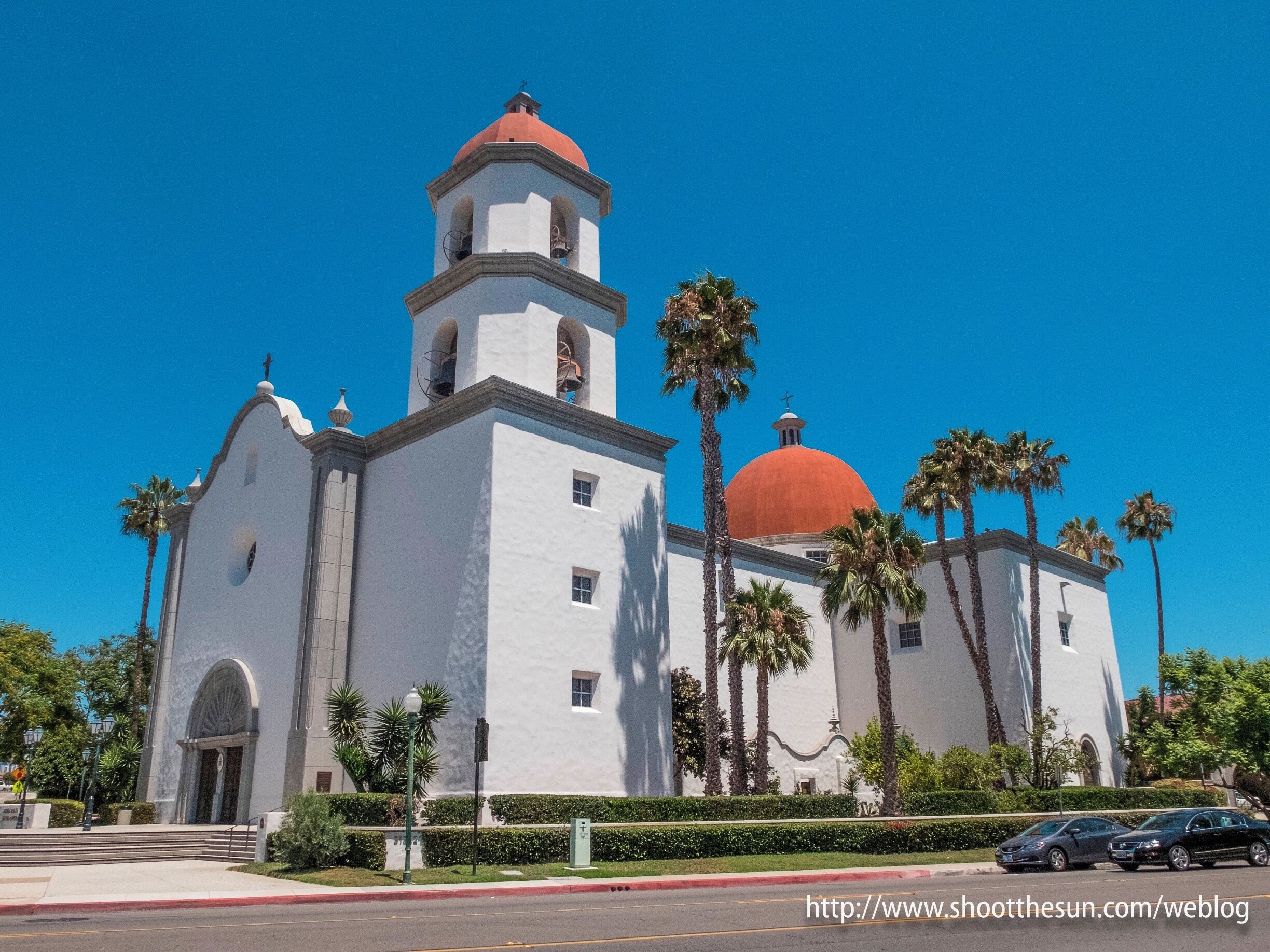 A white church with a red dome and a bell tower.