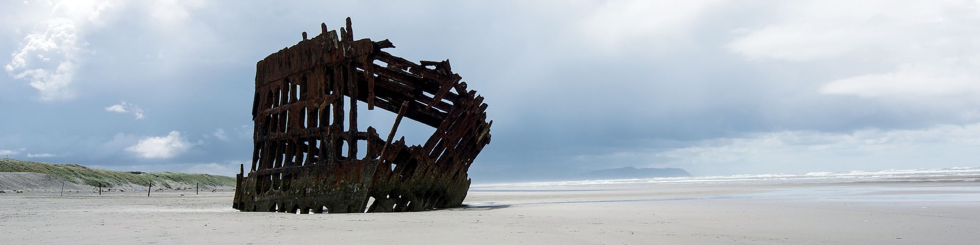 View of the Shipwreck of Peter Iredale at a beach in Warrenton, Oregon, USA. This four-masted steel barque sailing vessel ran ashore on October 25, 1906, en route to the Columbia River