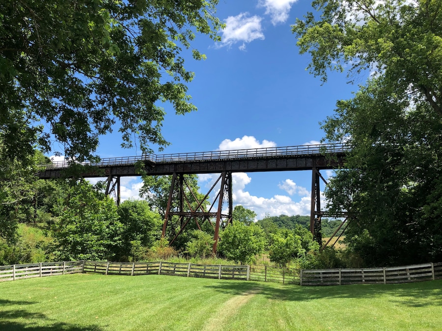 A metal bridge with a wooden fence in a green landscape.