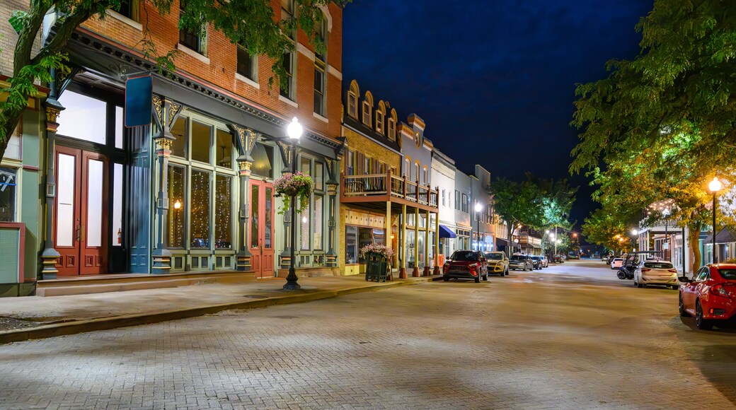 Early American buildings with shops and boutiques line the brick paved Main Street in the historic small town of St. Charles Missouri at night.