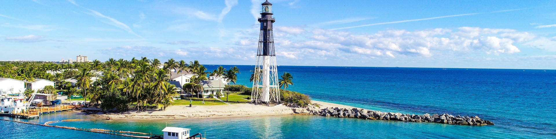 A lighthouse on a small island with clear blue skies and calm waters.