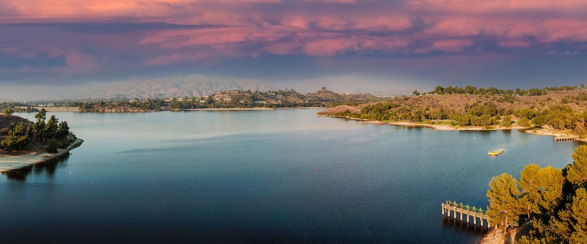 Un lago tranquilo rodeado de colinas y árboles.