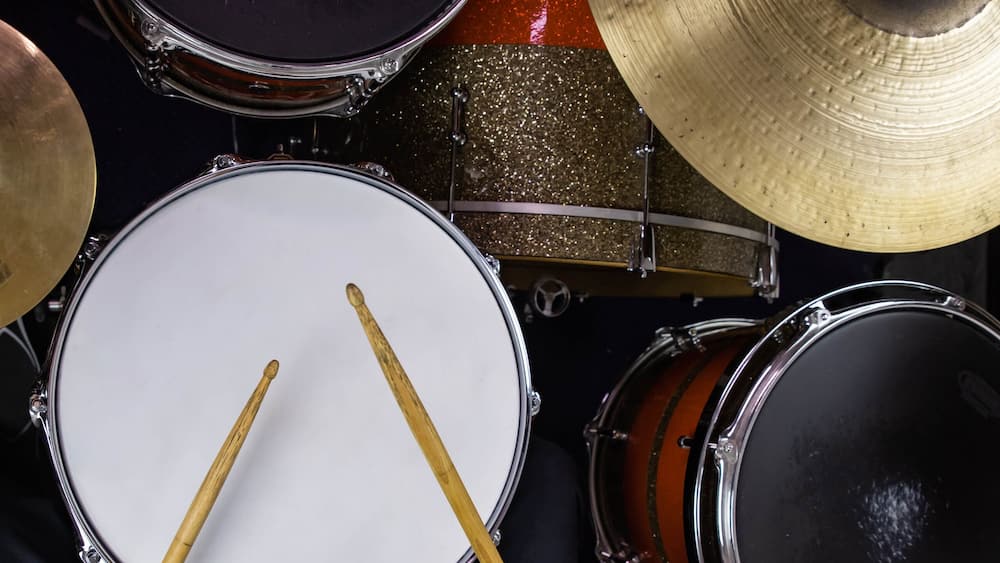 Musical instruments close up banner. Beautiful snare drum and hi-hat cymbals with drummer holding drumsticks. Modern drum set. Music shop.