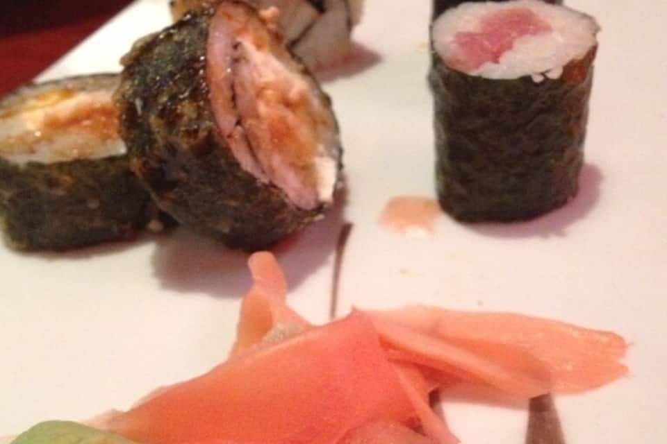 Een bord met sushirollen, met diverse vullingen en garneringen.