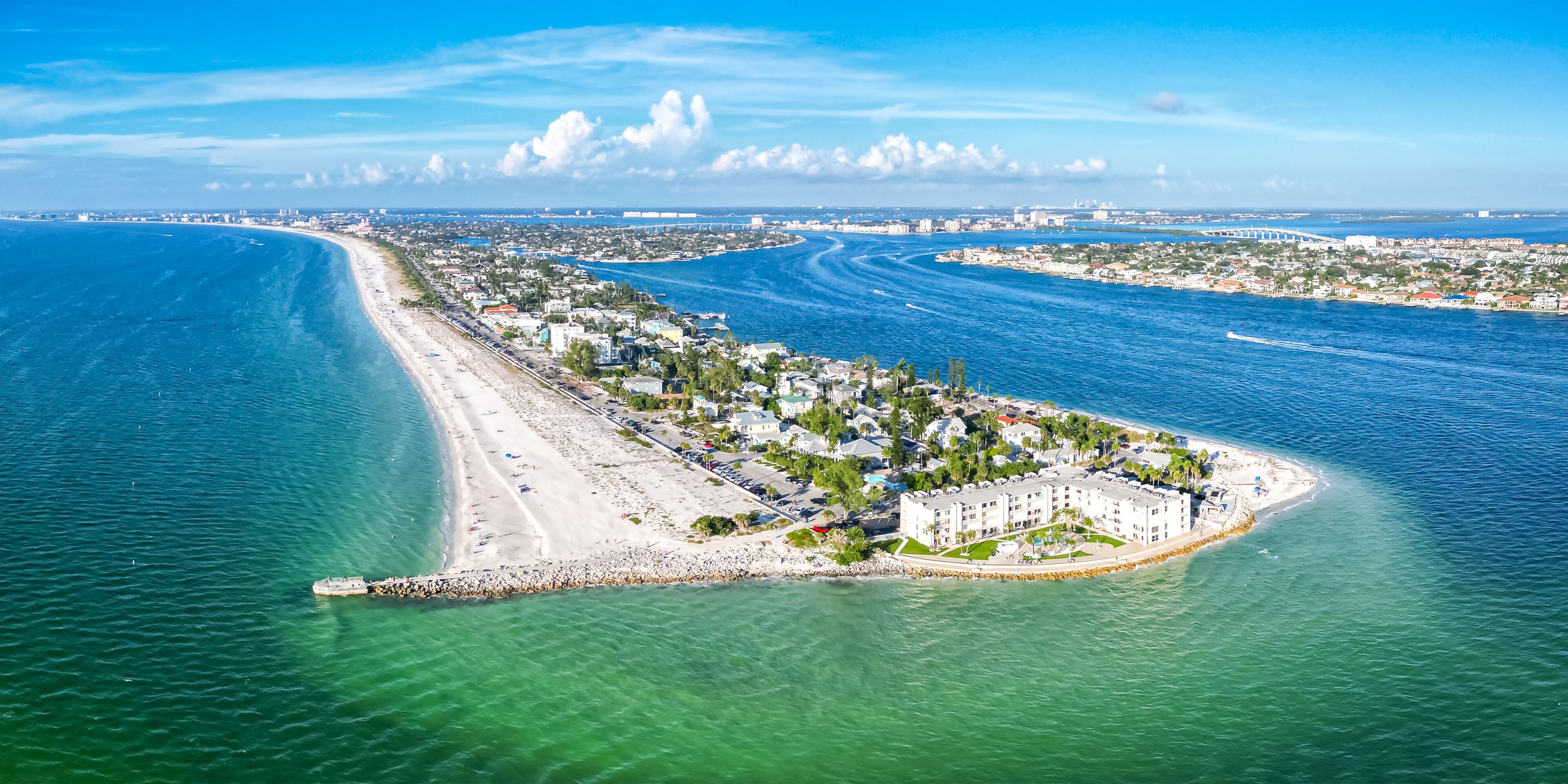 Eine Küstenstadtlandschaft mit einem markanten Strand, einer Marina und einem großen Gebäudekomplex.