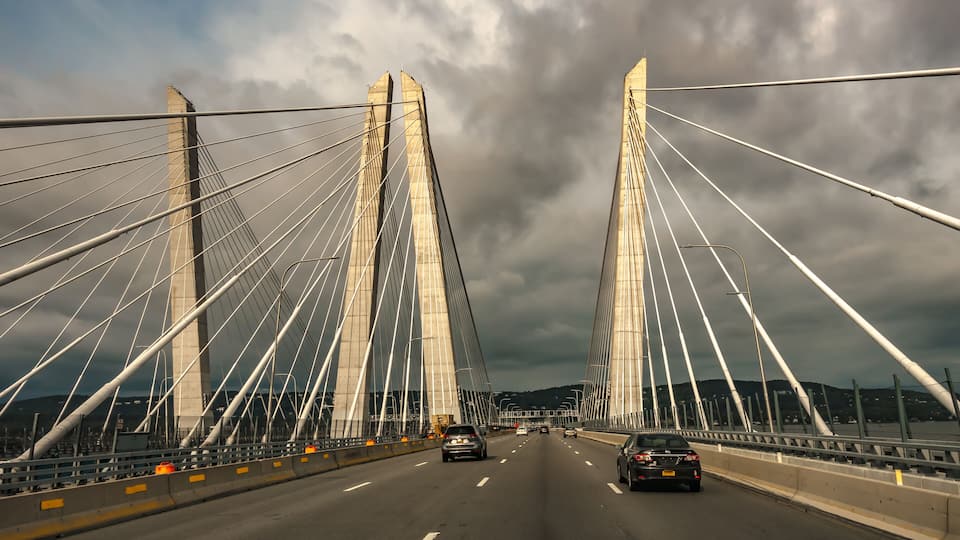 A cable-stayed bridge with multiple lanes and vehicles.
