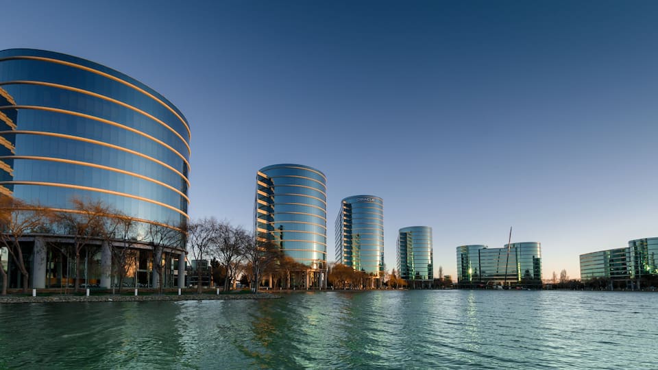 Modern buildings by a calm river.