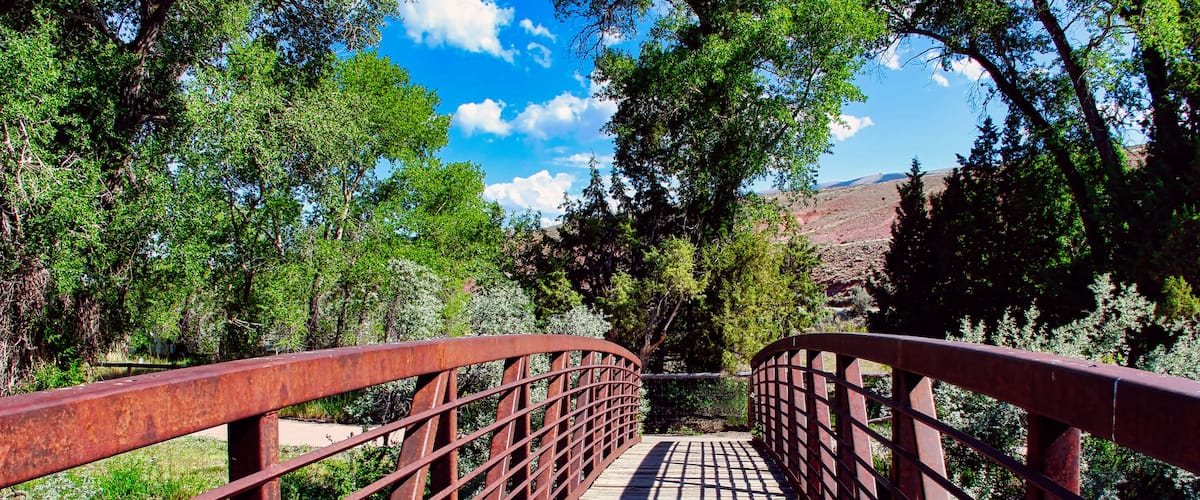Summer Day Walking on the Red Bridge over the Wind River at Dubois Town Park in Western Wyoming.