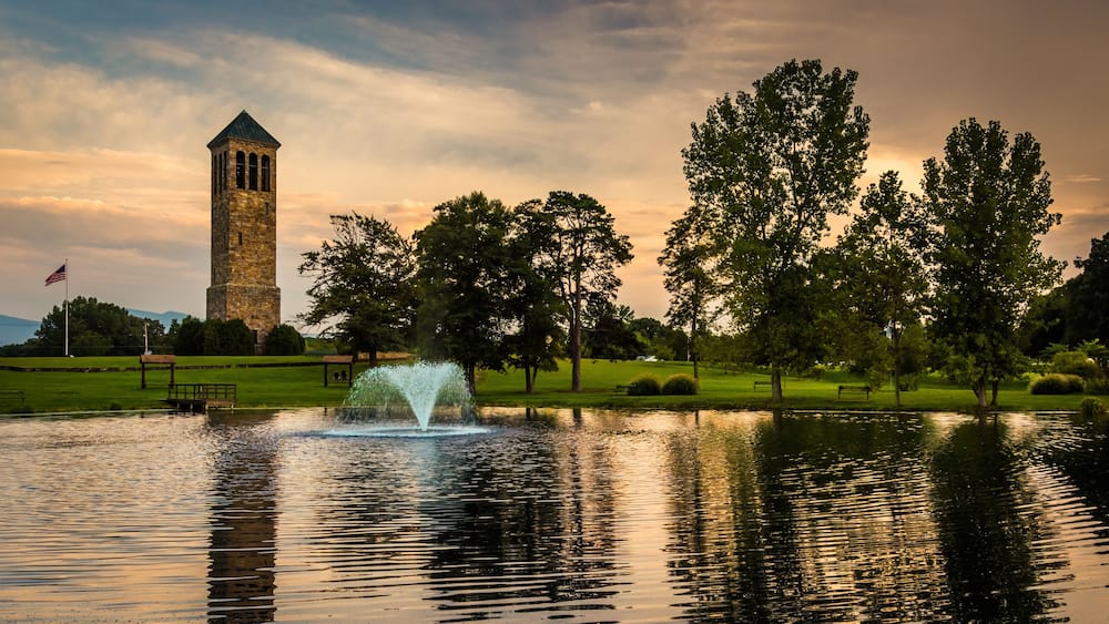 A tower, a fountain, and trees in a park.