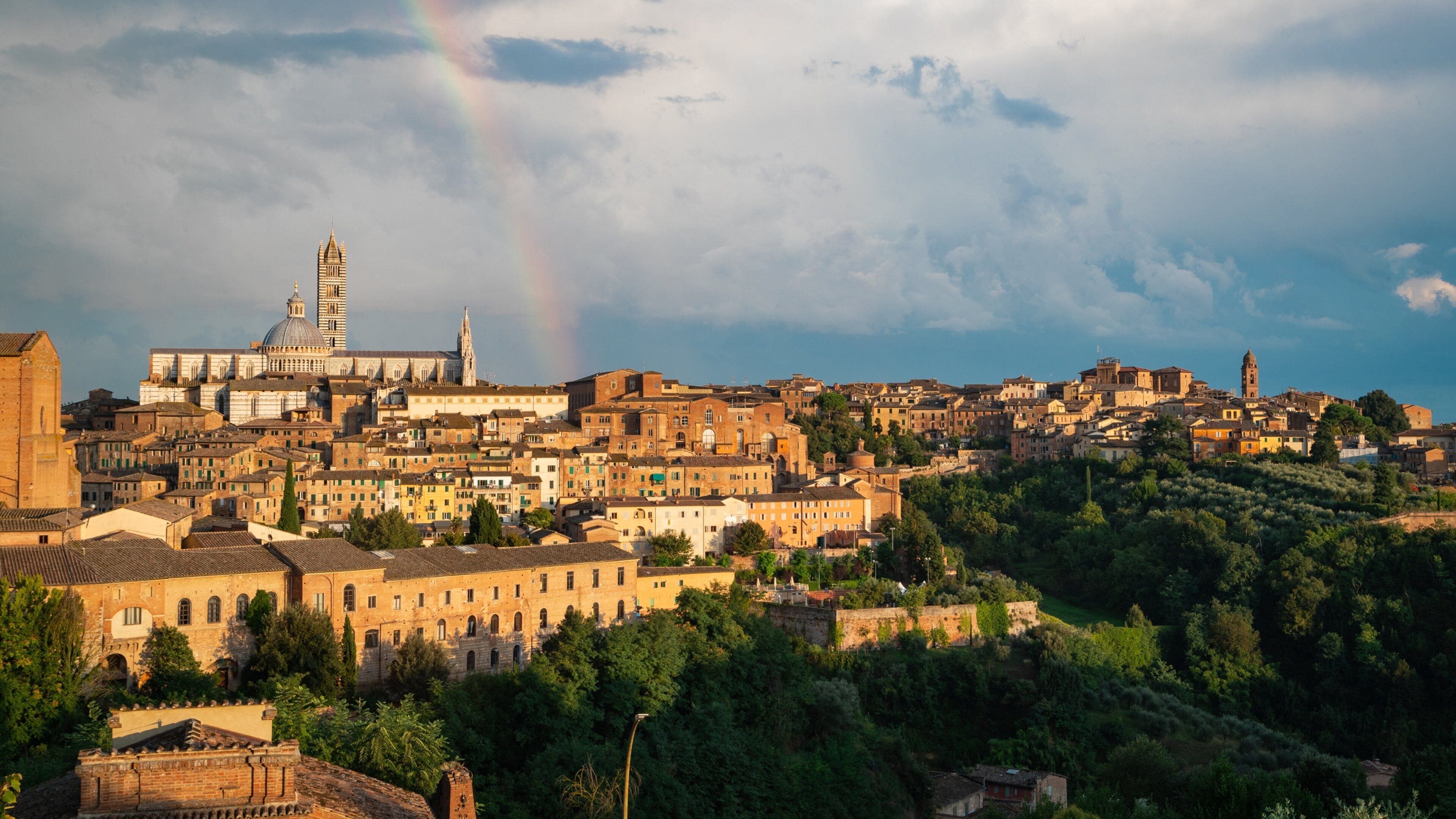 A cityscape with a prominent cathedral and a rainbow in the sky.